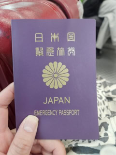 空港に向かうための安国駅のバス停で、上司や友人や両親に報告するため発行ホヤホヤの緊急旅券を撮影。赤でも青でもなく、ムラサキなんだねー。