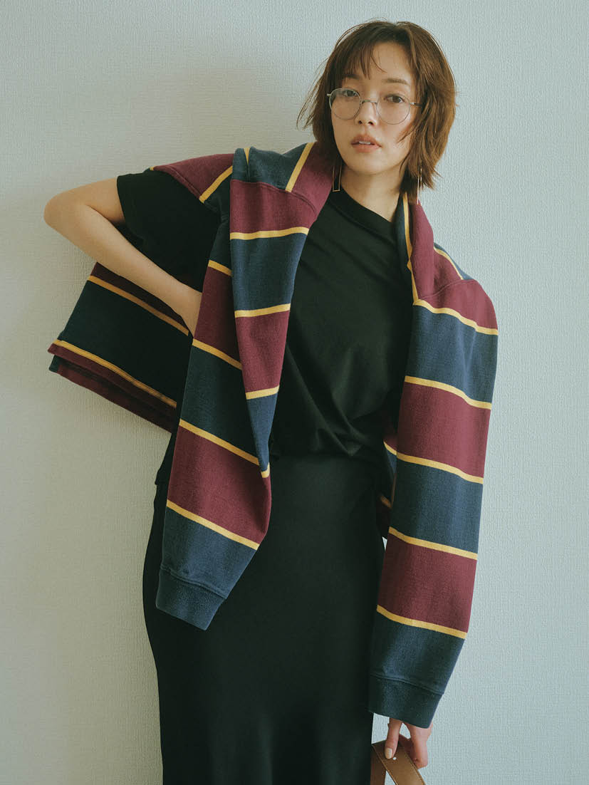 Tシャツ¥16,500（ハイク／ボウルズ）、肩に掛けたラガーシャツ¥7,150（原宿シカゴ／原宿シカゴ 神宮前店）、スカート¥28,930（エイチ ビューティー＆ユース）、メガネ※フレームのみ¥49,500（アメリカン オプティカル／メイデン・カンパニー）、ピアス¥198,000（トーカティブ／トーカティブ 表参道）、バッグ¥143,000（ツチヤカバン／土屋鞄製造所）