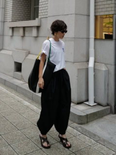カジュアルなTシャツをバルーンパンツで個性的にまとめながらも、モノトーンをセレクトすることでモードな雰囲気に昇華。バッグのハンドルやTシャツのロゴで差したビタミンカラーがさり気ないポイントにも。