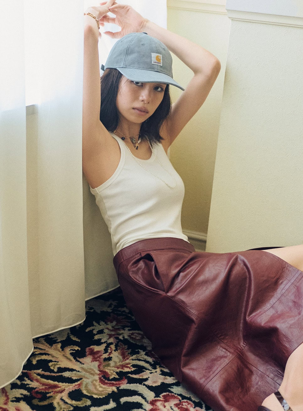 深めのスリットがタフなレザースカートで女っぽくなり過ぎないように。キャップのラフさがいいさじ加減。タンクトップ¥11,000（アワワコール／ワコールお客様センター）、レザースカート¥60,000（COS／COS 青山店）、キャップ¥9,900（カーハート WIP／カーハート WIP ストア トーキョー）、パールロングネックレス¥14,300、パール×メタルネックレス¥19,800、チャームネックレス¥19,800（全てanca.／ロードス）、ブレスレット¥223,300（シャルロット シェネ／シャルロット シェネ 青山店）、ミュール¥163,900（ジャンヴィト ロッシ／ジャンヴィト ロッシ ジャパン カスタマーサービス）