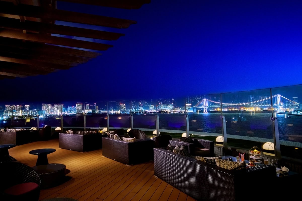 ホテルのオープンエアなテラス席から見渡す東京湾の絶景。ライトアップされたレインボーブリッジの夜景を特等席で楽しむ、大人の夏の涼活・癒やし空間。