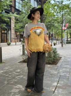 Tシャツ×デニムの王道ワンツーコーデに、レースのキャミを重ねるだけで即旬スタイルが完成! Tシャツのプリントとリンクさせたマスタードカラーのキャミソールがニクイ。