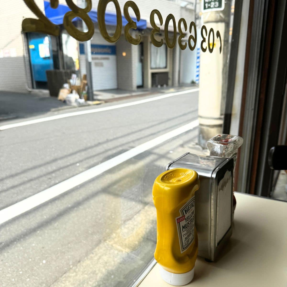 「アレイキャッツ」の窓際の特権。賑やかな祐天寺の商店街を眺めながら、自分だけの時間が流れる静寂に浸る。別の世界にいるような優雅な時間。