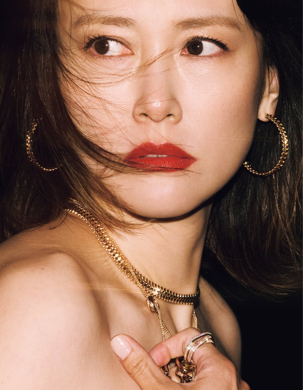 ネックレス 上〈クラッシュ ドゥ カルティエ〉［YG］¥4,567,200、同 イヤリング［PG］¥1,570,800、ネックレス 下〈トリニティ〉［WG×YG×PG×DIA］¥1,650,000、同 リング［WG×YG×PG×DIA］¥4,989,600、同 右手に持ったネックレス［WG×YG×PG］¥11,484,000（全てカルティエ／カルティエ カスタマー サービスセンター）