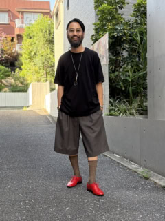 GGGのTシャツ、コム デ ギャルソンのタンクトップとハーフパンツ、眼鏡は不明、アンティークティファニーのルーペ、カシオの時計、クロムハーツのブレスレット、コンリードのソックス、カルマンソロジーのシューズは神谷さんの私物