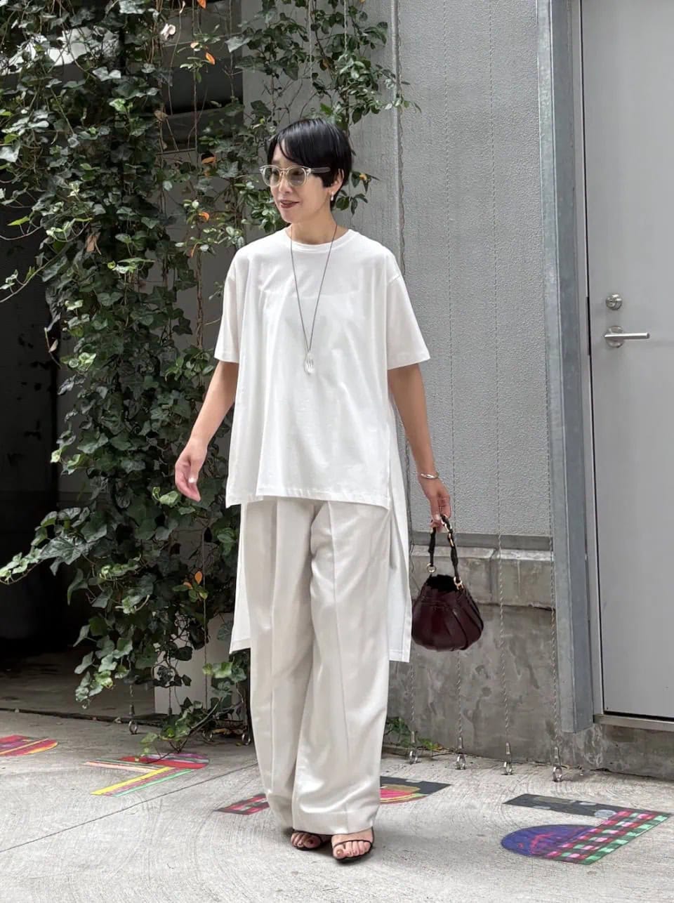 トーンオントーンのシンプルなワンツーコーデながら、ロングテールをきかせたTシャツが程よいアクセントに。ネックレスとアイウェアのクリアな質感もワントーンにメリハリを演出するポイント。