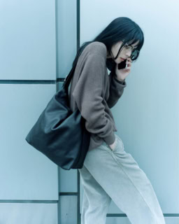 バッグ〈ジーン ショルダー〉［H35×W35×D15㎝］¥676,500、ニット¥268,400、カットソー¥102,300、中に着たニット¥233,200、パンツ¥233,200（全てザ･ロウ／ザ･ロウ・ジャパン）、メガネ¥61,600（アイヴァン／アイヴァン 東京ギャラリー）