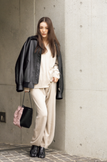 ニットフーディ¥44,000、ニットパンツ¥39,600（共にカオス／カオス表参道）、MIU MIUのレザージャケット、THE ROWのバッグ、バッグにつけたMIU MIUのキャップ、Maison Margielaのシューズは本人私物