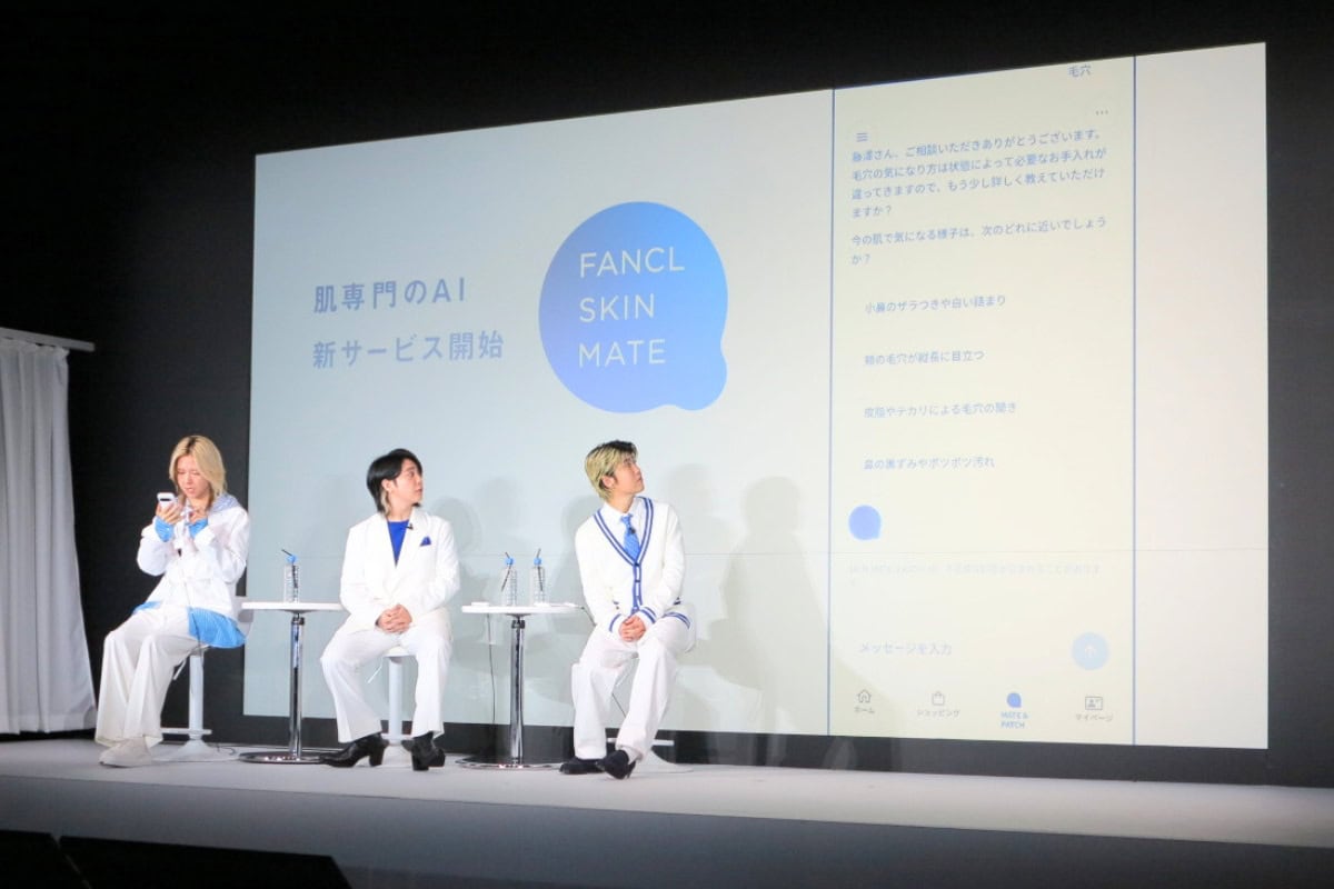 スマホを手にして実際に「顔画像解析」や「スキンメイト」のチャット体験に夢中になるメンバーの皆さん。