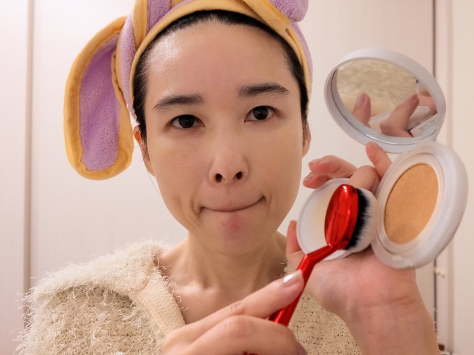 クッションファンデの表面をブラシで軽くトントンと叩く。本当に少しだけ取るのがポイント。クッションファンデは何を使ってもそんなに差がつかないので、お手持ちのものでOK。